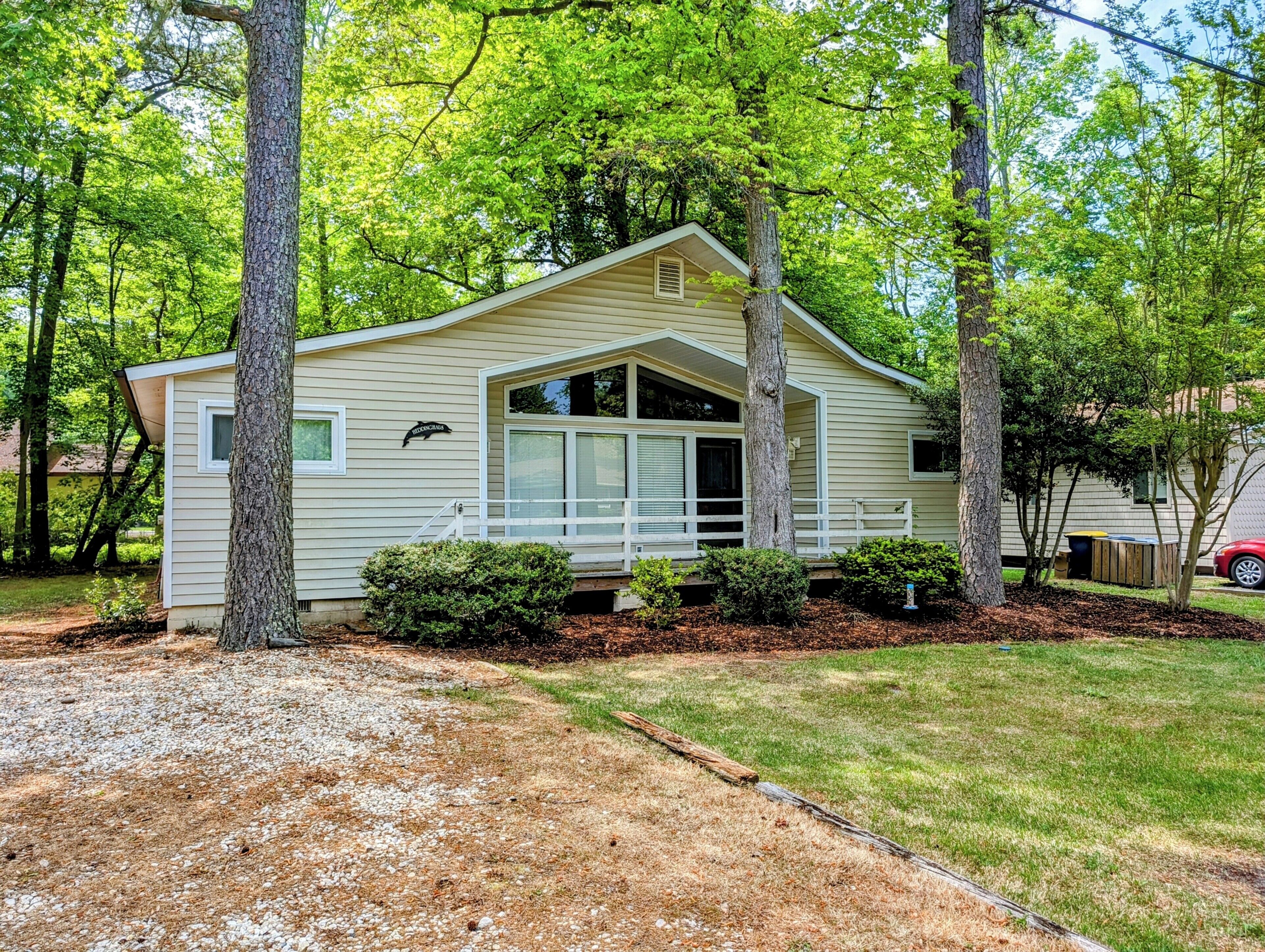529 Fairway Drive - Property Exterior - A welcoming view of this classic Bethany Beach vacation home, set on a private, shaded lot with beautiful mature trees and a long gravel driveway. The serene setting is just minutes from the coast.