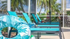 Un área junto a la piscina con sillas de descanso y un flotador.