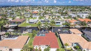 Una zona residencial con casas, un puerto deportivo y una casa grande con tejado rojo.