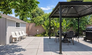 A patio with a covered seating area, a barbecue grill, and a shed with chairs. - Disneyland/Knott's, 6BR, 4BA, 3000 sqft, No Tax (Anaheim)