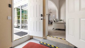 A hotel entrance with a white door, a red mat, and a yellow and black caution tape. - Disneyland/Knott's 6BR, 4BA, 3000 sqft, No Tax (Anaheim)