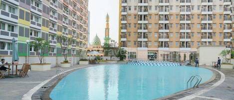 A swimming pool surrounded by multi-story residential buildings with balconies.