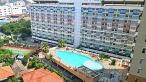 A multi-story hotel with a rooftop swimming pool and a tennis court. - Capital O 93937 Aditya Rooms  (Depok)