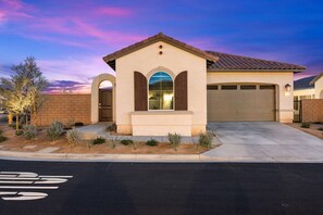 A residential house with a garage, a driveway, and a landscaped front yard.