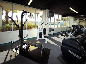 A gym with cardio machines, weight stations, and a bench. - Jade East Towers #650 | Gulf Front, Resort Pool + Near Popular Attractions! (Destin)