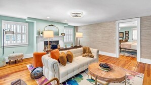 A spacious living room with a sofa, round coffee table, and a fireplace.