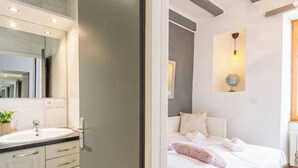 Un baño moderno con lavamanos, espejo y un espejo grande arriba.