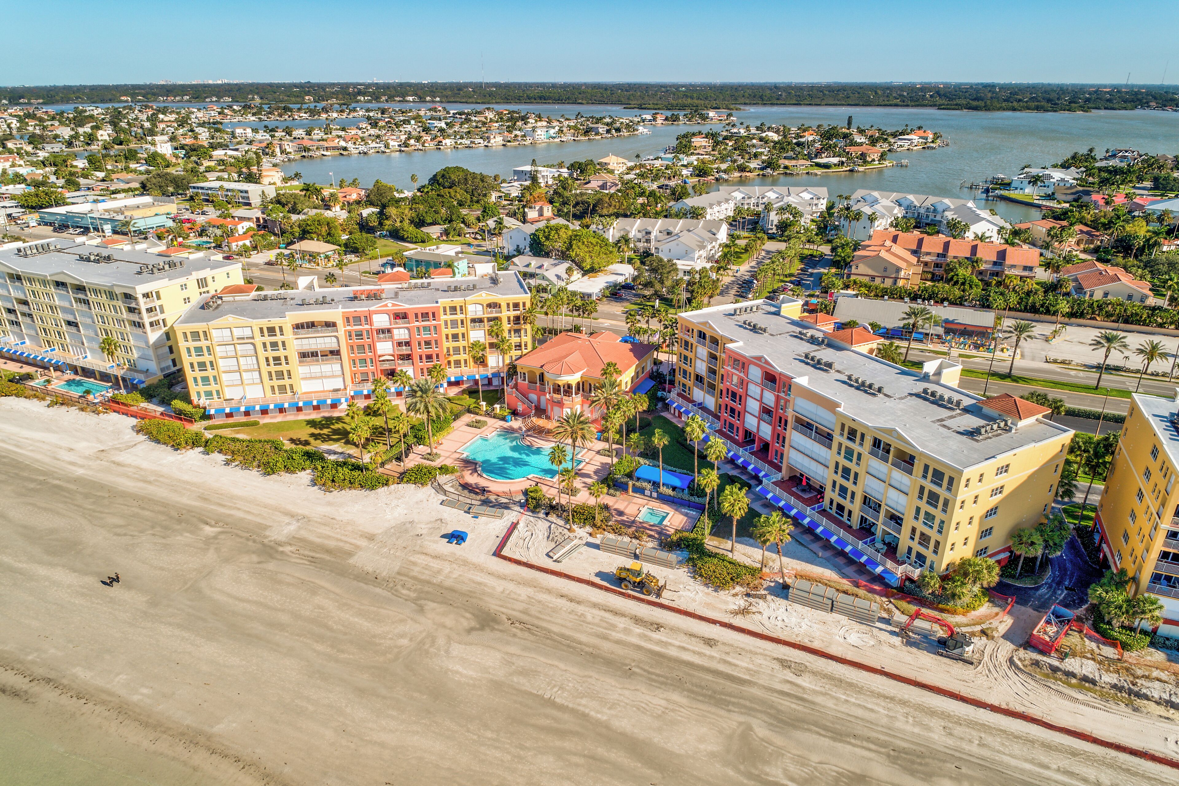 A coastal hotel with multiple buildings, a beach, and a marina.