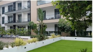 A multi-story residential building with balconies, a swimming pool, and well-maintained landscaping. - Embassy Gardens Cantonments Accra (Accra)
