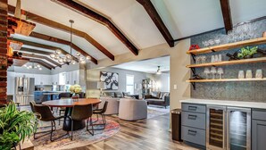A spacious kitchen with modern appliances, a dining area with a round table and chairs, and a living area with a sofa and coffee table. - Chic Family-friendly Home in Riverside: 7 Mi to KC (Riverside)