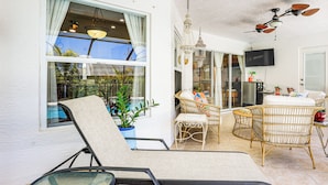 A sunlit patio with lounge chairs, wicker furniture, and a ceiling fan. - Near Parks: Port St Lucie Home w/ Private Pool! (Port Saint Lucie)