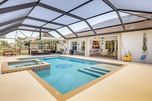 A swimming pool with a glass ceiling, a hot tub, and outdoor seating. - Near Parks: Port St Lucie Home w/ Private Pool! (Port Saint Lucie)