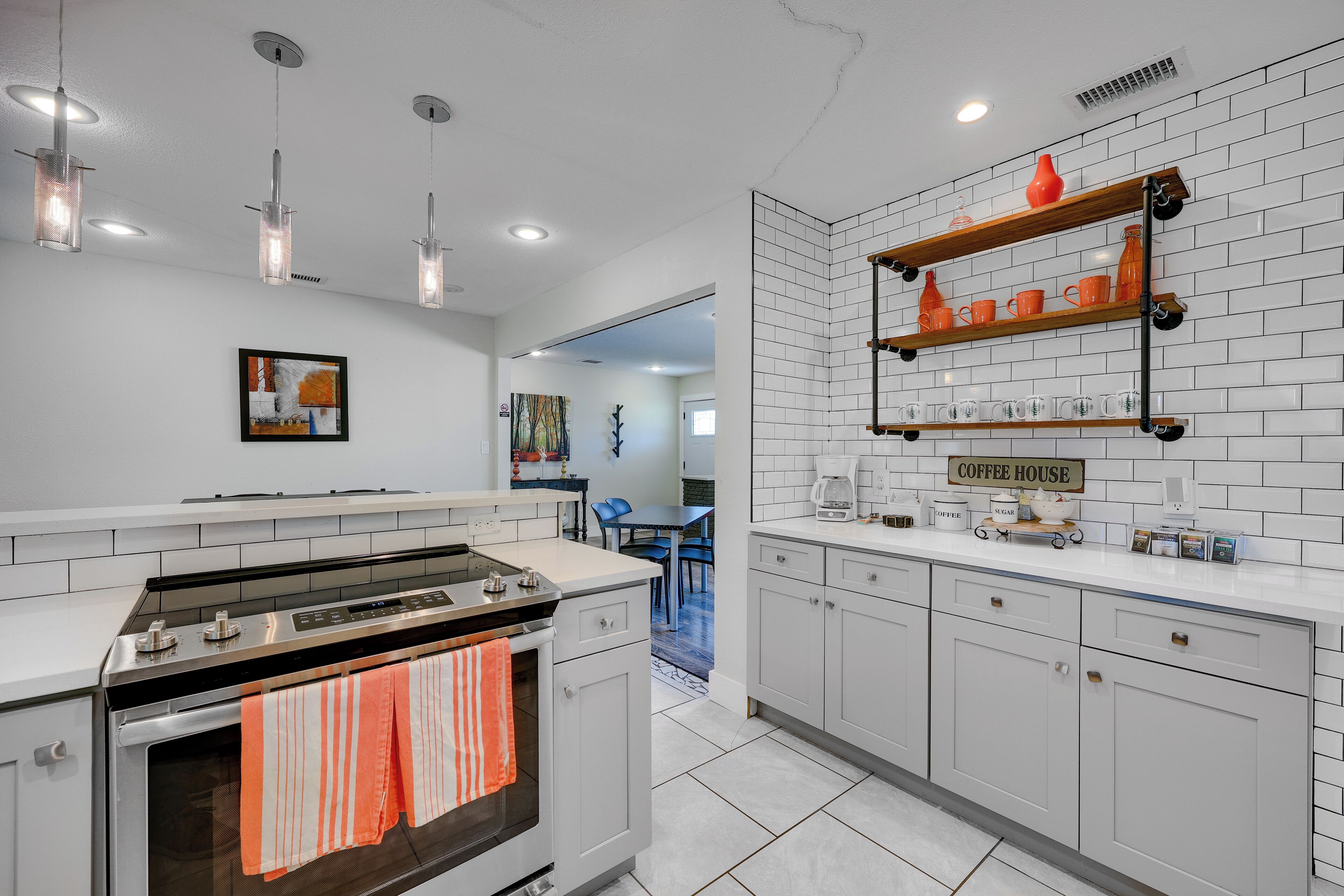 Una cocina moderna con armarios blancos, una isla central e iluminación colgante.