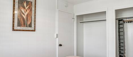 A bedroom with a bed, a wardrobe, and a ceiling fan.