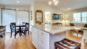 Una cocina amplia con una isla grande, sillas de madera y una mesa de comedor.