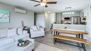 Un salon moderne avec un canapé, une table à manger et un ventilateur de plafond.