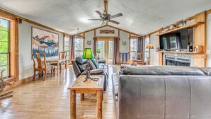 Amplia sala de estar con techo de madera, chimenea y televisor.