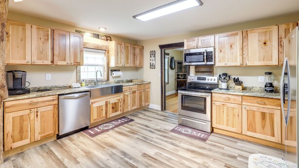 A modern kitchen with wooden cabinets, stainless steel appliances, and a central island. - Hike & Relax: Blue Ridge Mountain Retreat! (Burnsville)