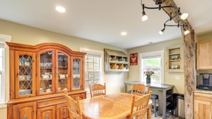 A dining area with a wooden table and chairs, a china cabinet, and a rustic wooden column. - Hike & Relax: Blue Ridge Mountain Retreat! (Burnsville)