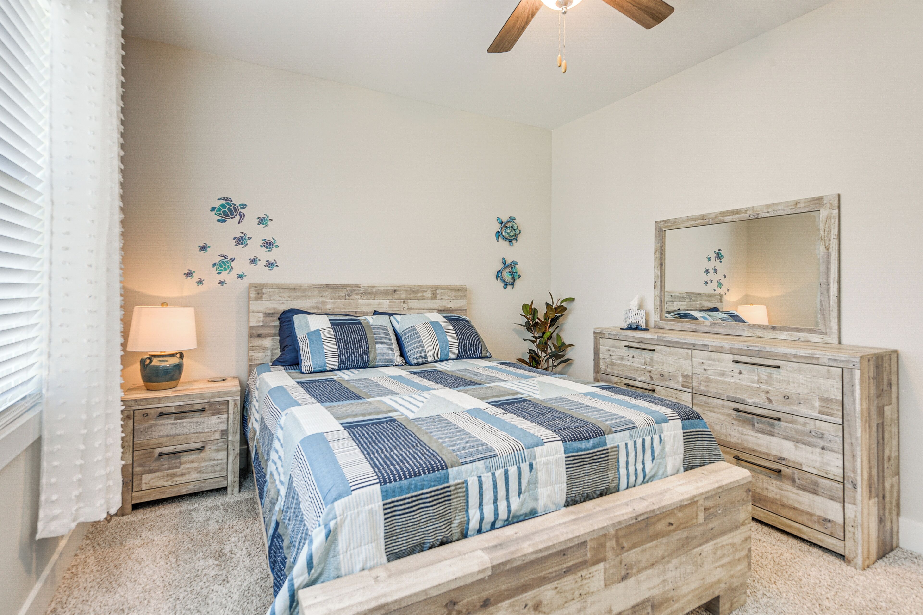 A bedroom with a wooden bed, a nightstand with a lamp, a dresser, and a mirror.