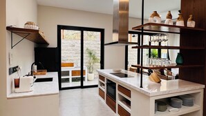 Una cocina moderna con una isla central, horno integrado y un amplio ventanal con vistas al exterior.
