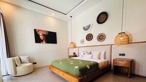 Un dormitorio moderno con una cama grande, un sofá, un televisor y adornos en la pared.