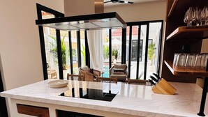 Una cocina moderna con una isla central, horno empotrado y cajones de almacenamiento de madera.