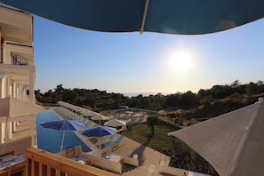 A poolside area with sun loungers and umbrellas, overlooking a hilly landscape. - Faralya Tuz Hotel (Fethiye)