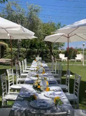 An outdoor dining area with tables set for a meal, surrounded by white chairs and large umbrellas. - Bed & breakfast in sorrento with pool and spa (Sorrento)