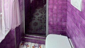 A bathroom with purple tiles, a glass shower enclosure, and a toilet. - Bed & breakfast in sorrento with pool and spa (Sorrento)