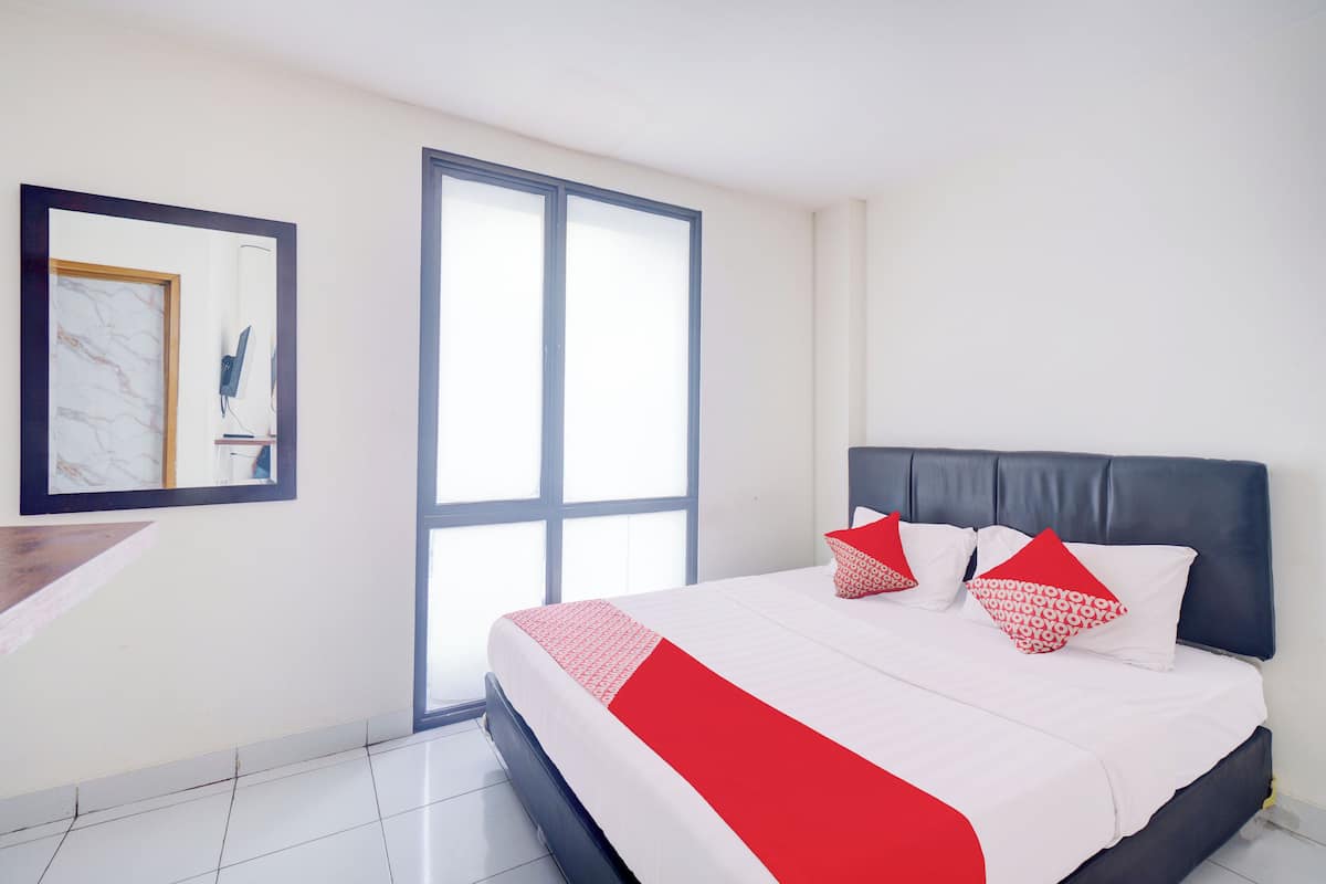 Een moderne hotelkamer met een groot bed, een bureau en een ruim venster.
