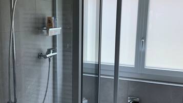 Een douche, een haardroger, handdoeken, toiletpapier