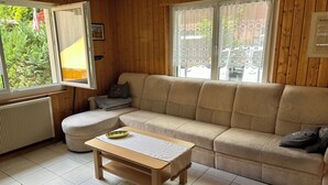 A cozy living room with a beige sectional sofa, a wooden coffee table, and a radiator. - Urlaub im Schönen Calancatal (Augio)