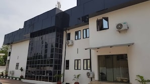 Un edificio moderno con facciata in vetro, tetto piano e un piccolo ingresso con gradini.