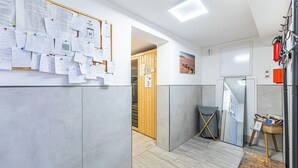 Een moderne kantoorruimte met een prikbord, een houten deur, een whiteboard en een klein tafeltje met een mand.
