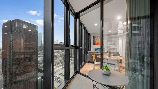 Un interior moderno con ventanas amplias, una zona de comedor y vistas a la ciudad.