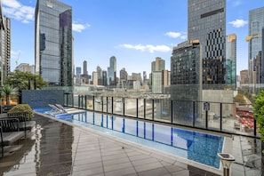 A rooftop pool with a city view, surrounded by high-rise buildings. - North Facing Skyline Views near Crown & Yarra River (Southbank)