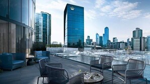 Terraza en la azotea con asientos y vistas a un horizonte urbano.