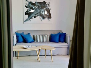 Un salon moderne avec un canapé gris, des coussins bleus et une table basse en bois.