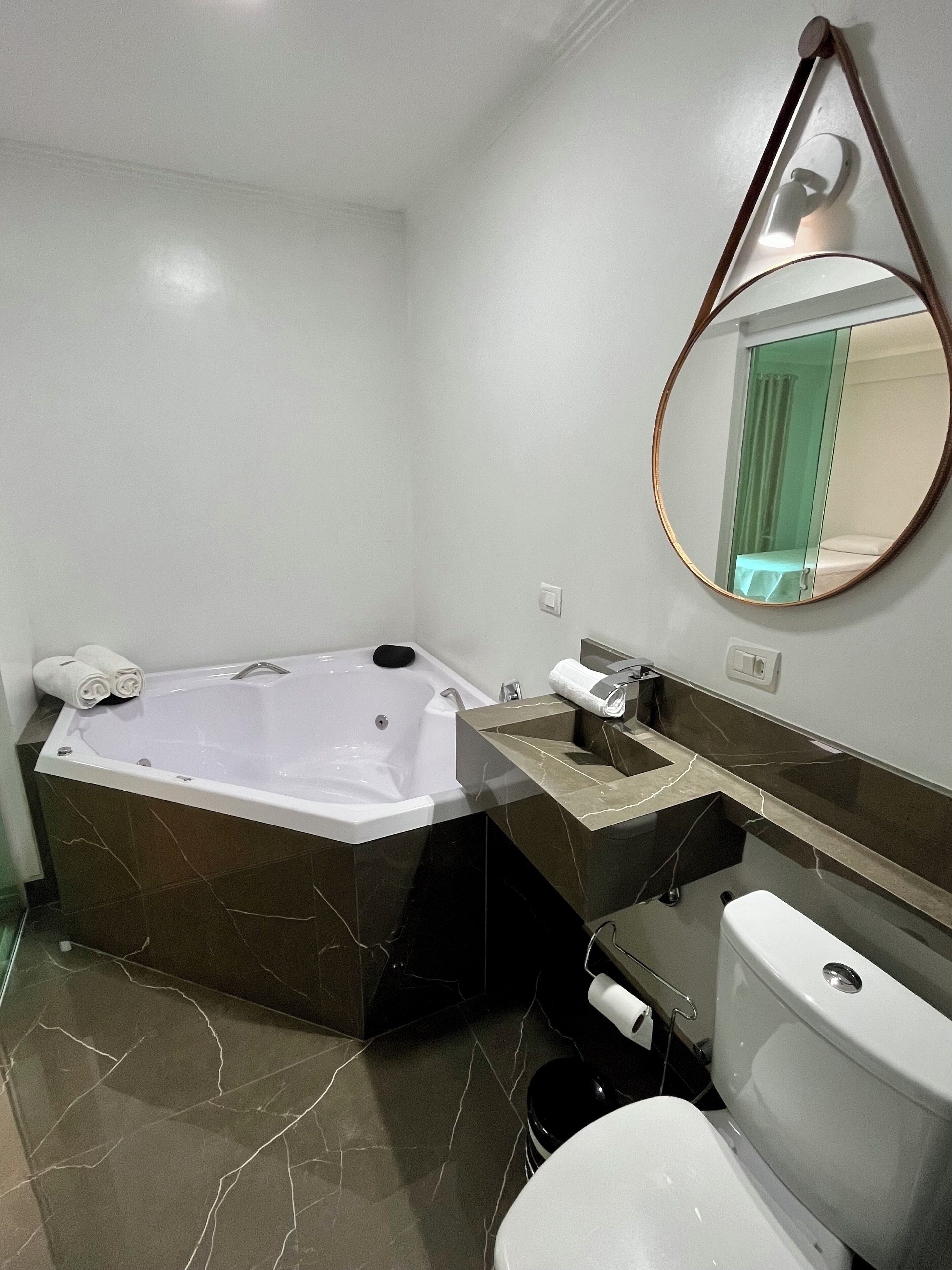 Une salle de bain moderne avec une baignoire sur pieds, un meuble-lavabo et des toilettes.