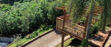 A wooden deck with a view of a lush green landscape and a river.