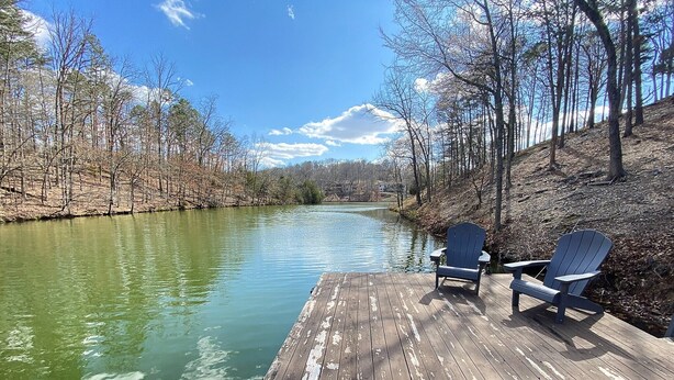 A wooden dock with two Adirondack chairs facing a calm river surrounded by trees. - Lakefront Cabin, Bella Vista Lake Rayburn Dock, MTB and family friendly (Bella Vista)