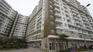 Un edificio residencial de varios pisos con balcones, un letrero de estacionamiento y un letrero de prohibido el paso.