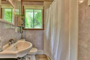 Ein Badezimmer mit Waschbecken, Toilette und Fenster.