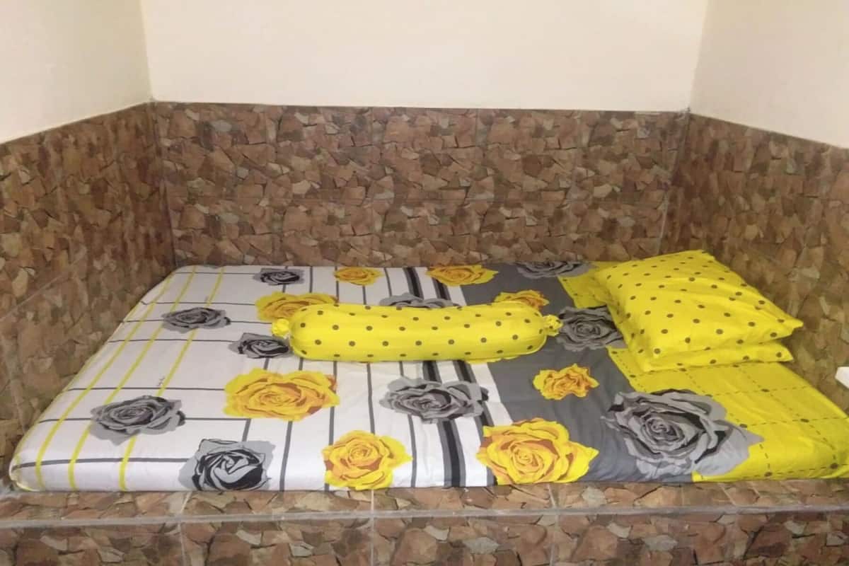 Un sofá de esquina con tela estampada y un fondo de pared de piedra.