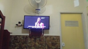 A television mounted on a wall with a stone fireplace below. - Hotel O Wisma Kost & Penginapan Afilia Buana Syariah (Tulungagung)
