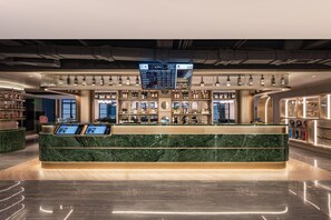 A modern bar area with a marble counter, overhead digital menu, and various liquor bottles. - Manxin Hotel Yantai Binhai Plaza (Yantai)