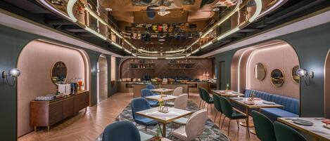 A modern interior with a bar area, seating, and a herringbone floor pattern.