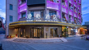 A hotel with a modern facade, large windows, and a sign indicating it is the Manxin Hotel. - Manxin Hotel Yantai Binhai Plaza (Yantai)