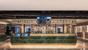 A modern bar area with a marble counter, digital menu displays, and a variety of bottles and glasses on shelves. - Manxin Hotel Yantai Binhai Plaza (Yantai)